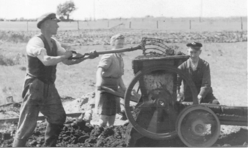 Torfpressen v.l. Peter Petersen, Frau Jäger, W. Frey